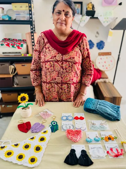 Here I am with a table full of small, handmade accessories ready to be shipped. This order for a former student included a crochet sunflower bandana, macrame keychains, earrings, and a woolen muffler.