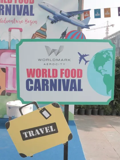 A shot of the World Food Carnival entrance sign, decorated with travel-themed props. This image sets the stage for a global culinary adventure.