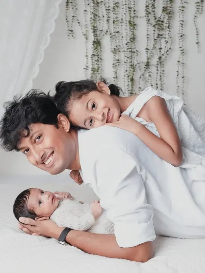 Dad joins in on the fun. A playful moment with a father, his daughter, and his newborn baby, creating a happy and dynamic family photo.