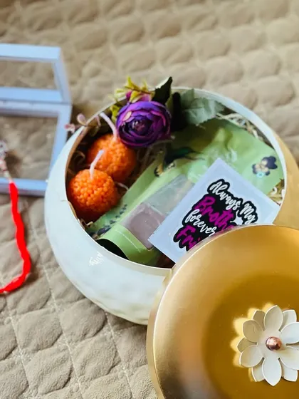 This unique Rakhi hamper uses a stylish ceramic pot as its base, making the container a gift in itself.