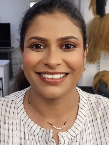 A smiling shot of the warm, brown smokey eye look. It’s a friendly and approachable take on a classic evening makeup style.