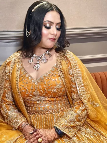 A close-up on the bride's face, showing the detailed eye makeup and the delicate hair accessory.