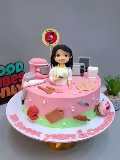 The full view of my 10th-anniversary cake, featuring a mini-me and all my baking tools.