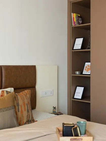 A close-up of the bedroom's smart design, showing a built-in bookshelf next to the wardrobe for easy access to nighttime reading.