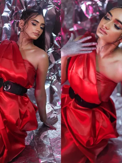 A dramatic editorial look featuring a model in a vibrant red dress with silver body paint accents, showcasing creative and conceptual makeup skills.
