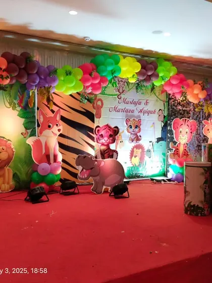 A team member making final adjustments to the jungle theme stage decor.