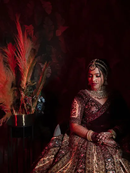 A full-seated portrait showing the bride in a moment of quiet contemplation. The lighting and composition give this image a very painterly feel.