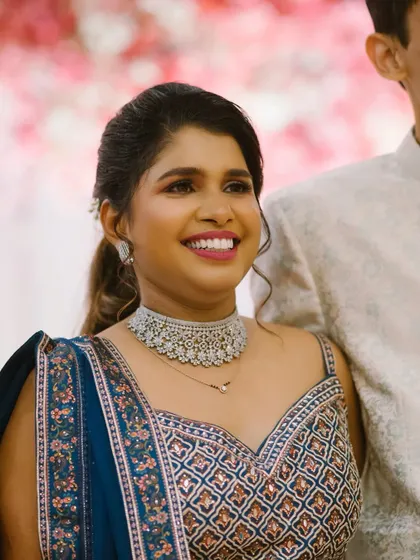 A radiant smile from the bride. This close-up shows her flawless reception makeup, featuring a bright pink lip and perfectly defined eyes.