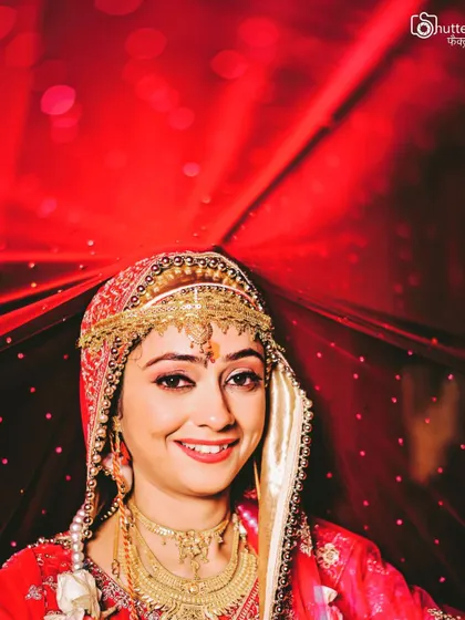 A beautiful portrait of a bride in her red lehenga, her eyes full of dreams. We aim to capture the emotion and anticipation of the wedding day.
