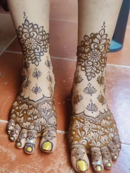 Another angle of the same floral and lotus foot design, showing the fresh henna paste.