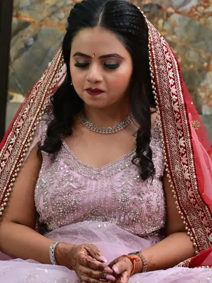 A beautiful shot of the bride looking down, showcasing her colorful eye makeup and bold lip.