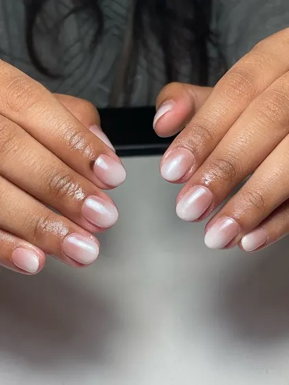 The "glazed donut" or "lip gloss" nail trend is perfect for a minimalist bride. It's a sheer, milky white ombré on short, natural nails that looks clean, healthy, and incredibly chic.