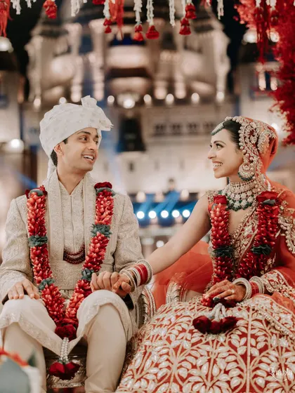 A moment of shared smiles and hand-holding during the wedding ceremony. This close-up captures the happy connection between Amala and Aditya.