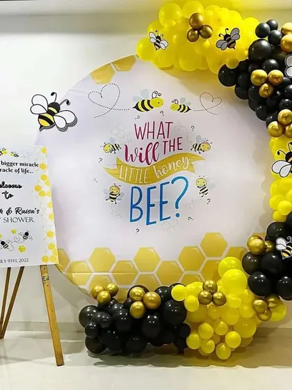 I create adorable and unique themes for baby showers. This "What will the little honey BEE?" gender reveal party features a honeycomb-themed backdrop, a balloon arch in black and yellow, and a matching welcome sign, creating a sweet and fun atmosphere for your celebration.
