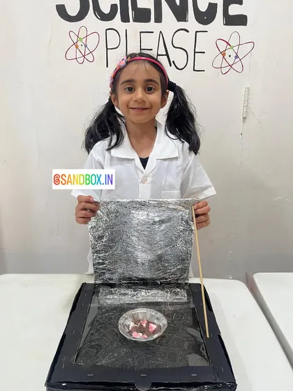 Proudly holding her solar cooker, this student is ready to harness the power of the sun. It's a great introduction to the concepts of solar energy and heat transfer.