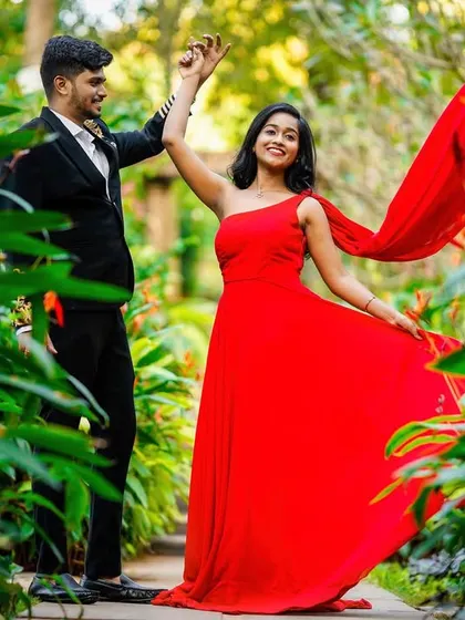 A candid and joyful dancing moment in a lush green pathway.