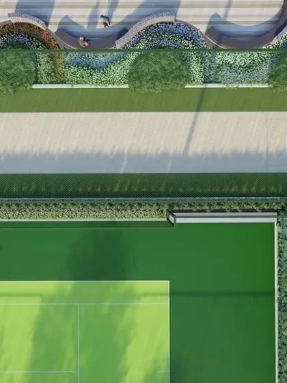 An overhead view of the cricket pitch and tennis court at 'Villa on Sky', showcasing the clean, geometric layout and integration with adjacent seating areas.