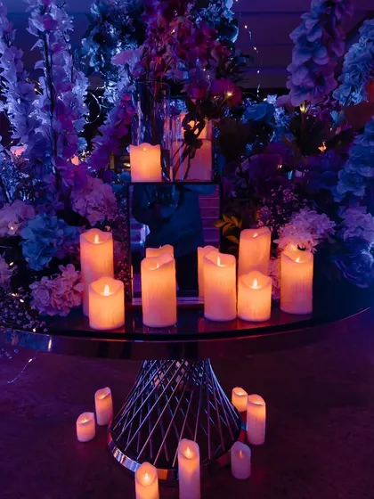 A detail shot of the celestial Sangeet decor, with candles providing a warm glow against the cool blue lighting.