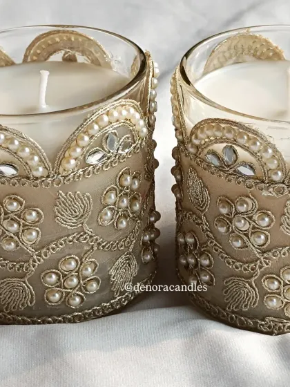 A close-up of the intricate embroidery and pearl work on the decorative jar candles.
