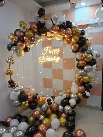 A full circular balloon arch in black, white, and mixed metallics, complete with a neon sign and fairy light curtain. This versatile design can be adapted for any anniversary party, offering a complete photo-ready backdrop.