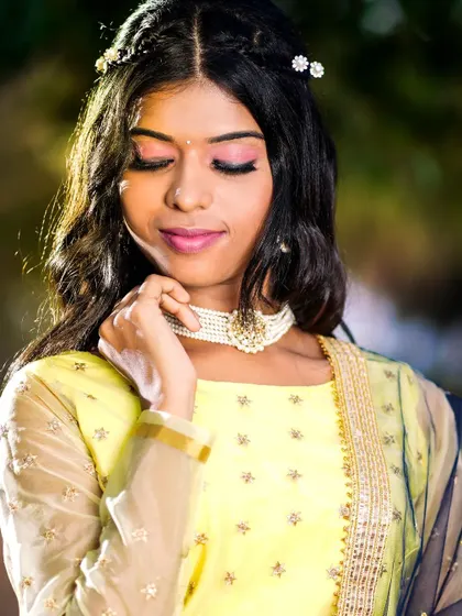 A close-up of the yellow lehenga look, paired with a simple and elegant pearl choker. A great rental option for a daytime event.