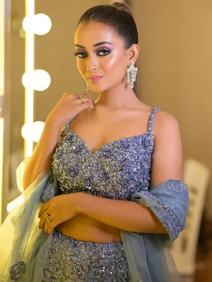 This dusty blue lehenga is adorned with intricate beadwork and sequins. The spaghetti-strap blouse adds a modern and delicate touch.