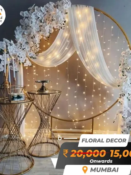 A modern and chic circular backdrop with white florals, fairy lights, and gold accents. This is a popular choice for engagements and receptions.