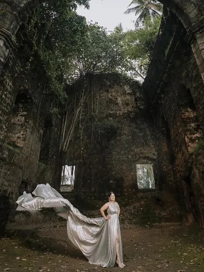 This client looks incredible in our silver trail gown during her pre-wedding shoot in a historic location. The flowing fabric creates a magical, ethereal effect.