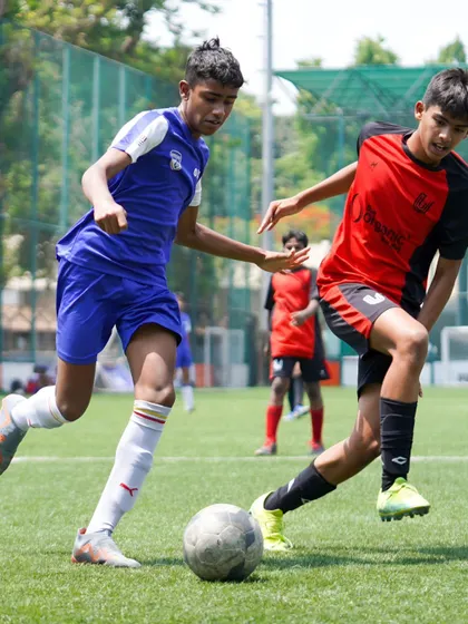 Two players engage in a tough tackle, showcasing the competitive and physical nature of the game we prepare them for.