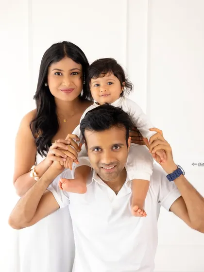 A fun and playful family pose, with the baby sitting on dad's shoulders. This is a great way to capture the joyful side of family dynamics.