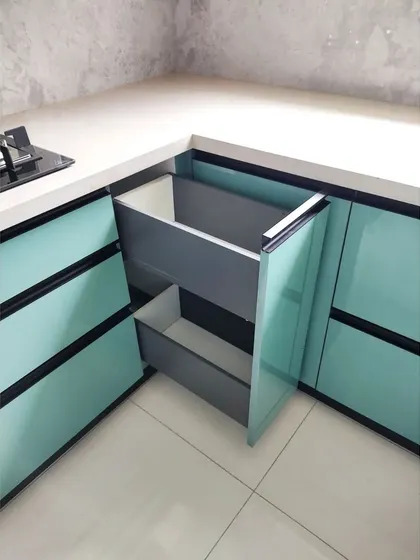A dedicated pull-out unit for waste and recycling bins, neatly concealed within a cabinet. This solution keeps trash out of sight and helps maintain a clean and hygienic kitchen environment.