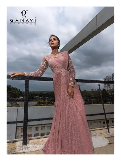 This fabulous fusion piece is a statement indo-western saree gown. The pre-draped silhouette and embroidered full-sleeve blouse offer a modern, hassle-free take on traditional wear.