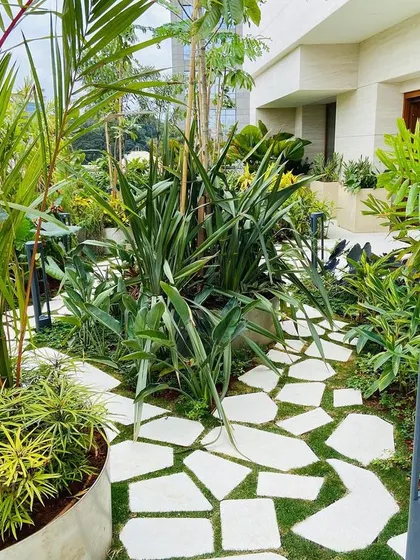 This pathway design uses irregular-shaped pavers set in grass to create an organic, natural feel. It connects different zones of the terrace garden while adding visual interest to the ground plane.
