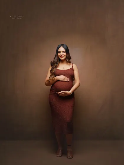 A full-length solo portrait against a warm, neutral backdrop. This shows how we can create a professional studio look even during a shoot at your place.