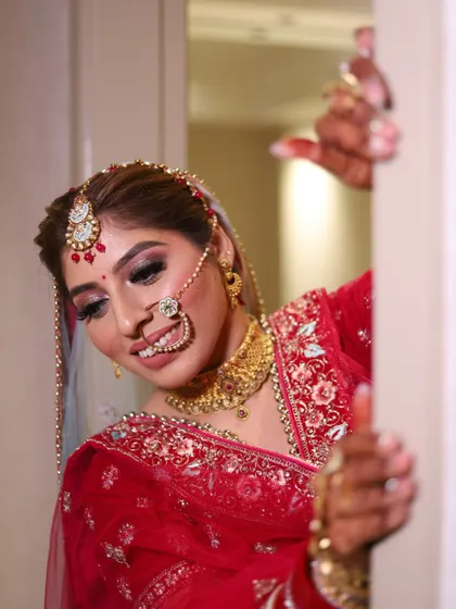 A playful and shy pose from the bride, peeking from behind a wall during her photoshoot.