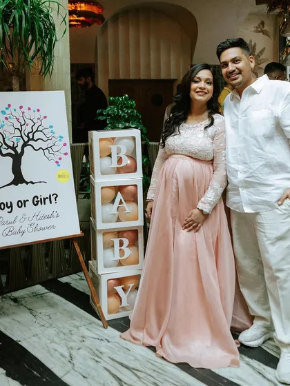 A classic baby shower setup with a "Boy or Girl?" fingerprint tree and transparent "BABY" boxes filled with balloons. It’s a timeless way to build anticipation and celebrate the parents-to-be.