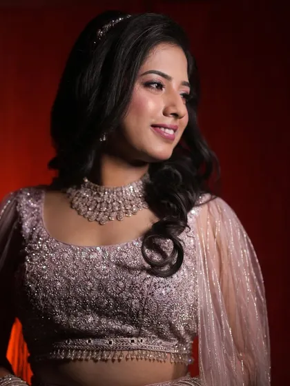 A professionally shot portrait for a reception. The makeup features a soft glittery eye and a subtle pink lip, which looks beautiful with her embellished lehenga and diamond necklace.