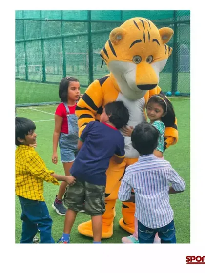 Kids gathering around for a hug with the tiger mascot. It's all about creating a warm, friendly, and exciting atmosphere at my sports-themed parties.