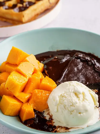 A decadent dessert bowl with fresh mango, chocolate sauce, and ice cream. We capture indulgent moments that make customers want to treat themselves.