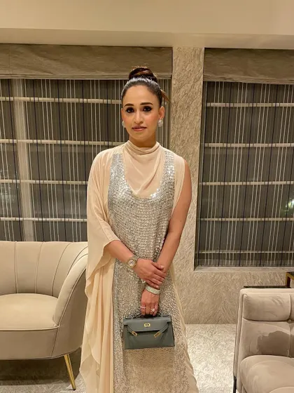 A beautiful front on shot of Sherry Anand's elegant top knot. This classic updo is perfect for showcasing statement earrings and a high neckline.