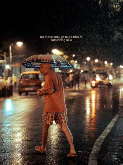 An old man with an umbrella crosses a wet street at night. Rainy nights are a gift for street photographers, as the reflections on the pavement and the soft light create a wonderfully moody and cinematic atmosphere.