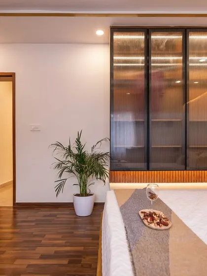 This shot highlights the combination of wood flooring and a fluted accent wall, adding layers of texture and warmth to the bedroom's design.