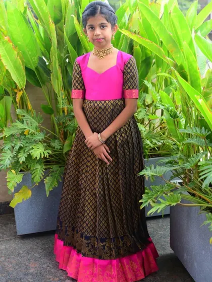 This custom long gown in black and pink brocade is a perfect example of modern ethnic fusion. The sweetheart neckline and contrasting colors give it a contemporary edge while honoring traditional fabrics.
