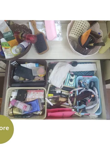 The "before" of a dressing table area. Drawers are overflowing with cosmetics, and the countertop is cluttered with brushes and products.