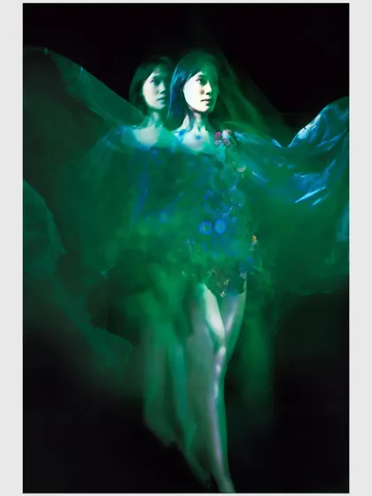 A creative double-exposure or long-exposure shot with green light, creating a ghostly twin effect. This technique visualizes the character's fractured mental state and inner conflict.