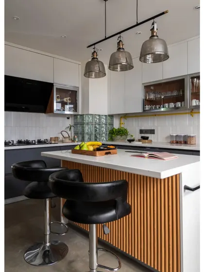 This featured image highlights the kitchen's blend of modern elegance and industrial flair. The fluted wood island, sleek countertops, and glass pendant lights create a sophisticated and functional culinary space.