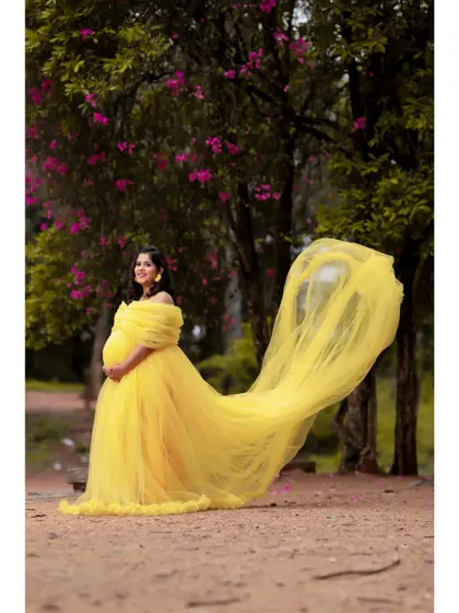 A beautiful shot of the yellow tail gown in a natural setting. The vibrant color stands out beautifully against the trees, making your maternity photos pop.