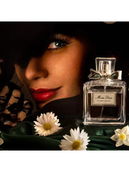 A classic and elegant product shoot for Miss Dior perfume. The composition combines a model's evocative look with careful still life arrangement to create an image of sophistication and allure for a luxury brand campaign.