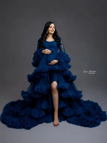 A vision in royal blue. This ruffled, high-slit gown is pure glamour, and the rich color looks absolutely stunning against a simple grey backdrop.