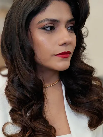 The side profile showcases the beautiful vintage waves and the clean lines of the makeup. A truly elegant and timeless party look.